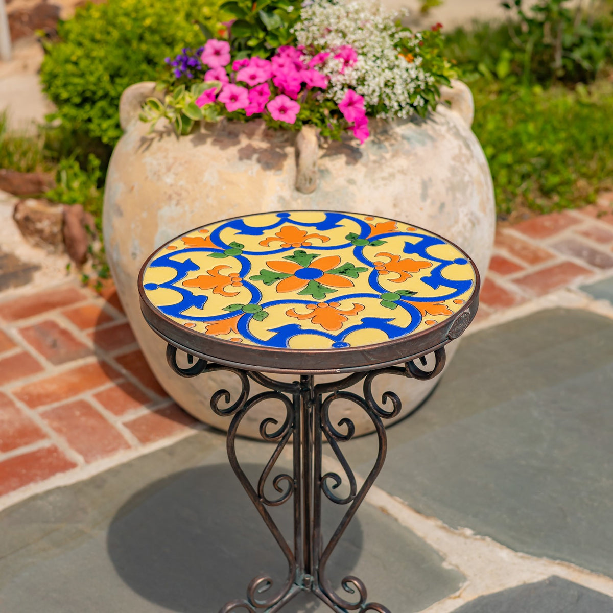 Close view of the circular mosaic surface and curved metal supports against a patio.