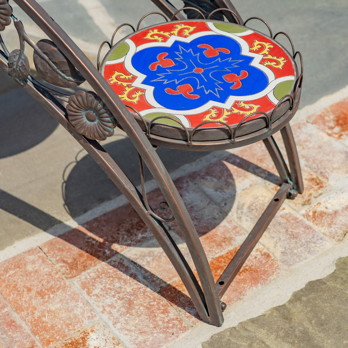 Close-up of a round red, blue, and cream mosaic shelf within its metal rim.