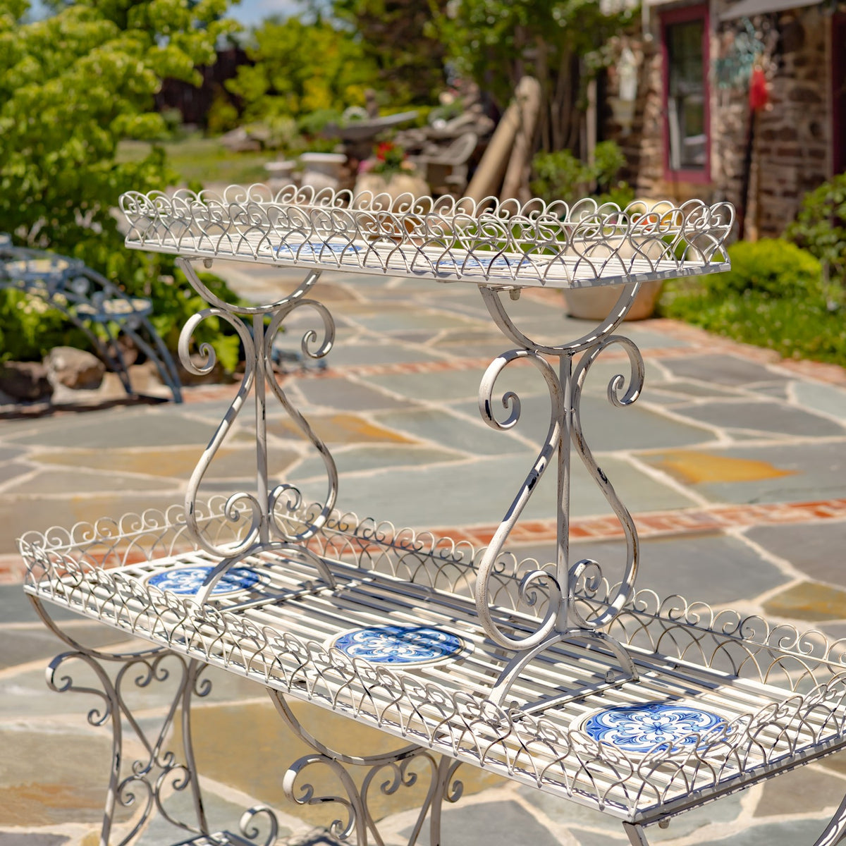 Angled view highlighting the stand’s ornate white metal supports and raised wire shelf edges.