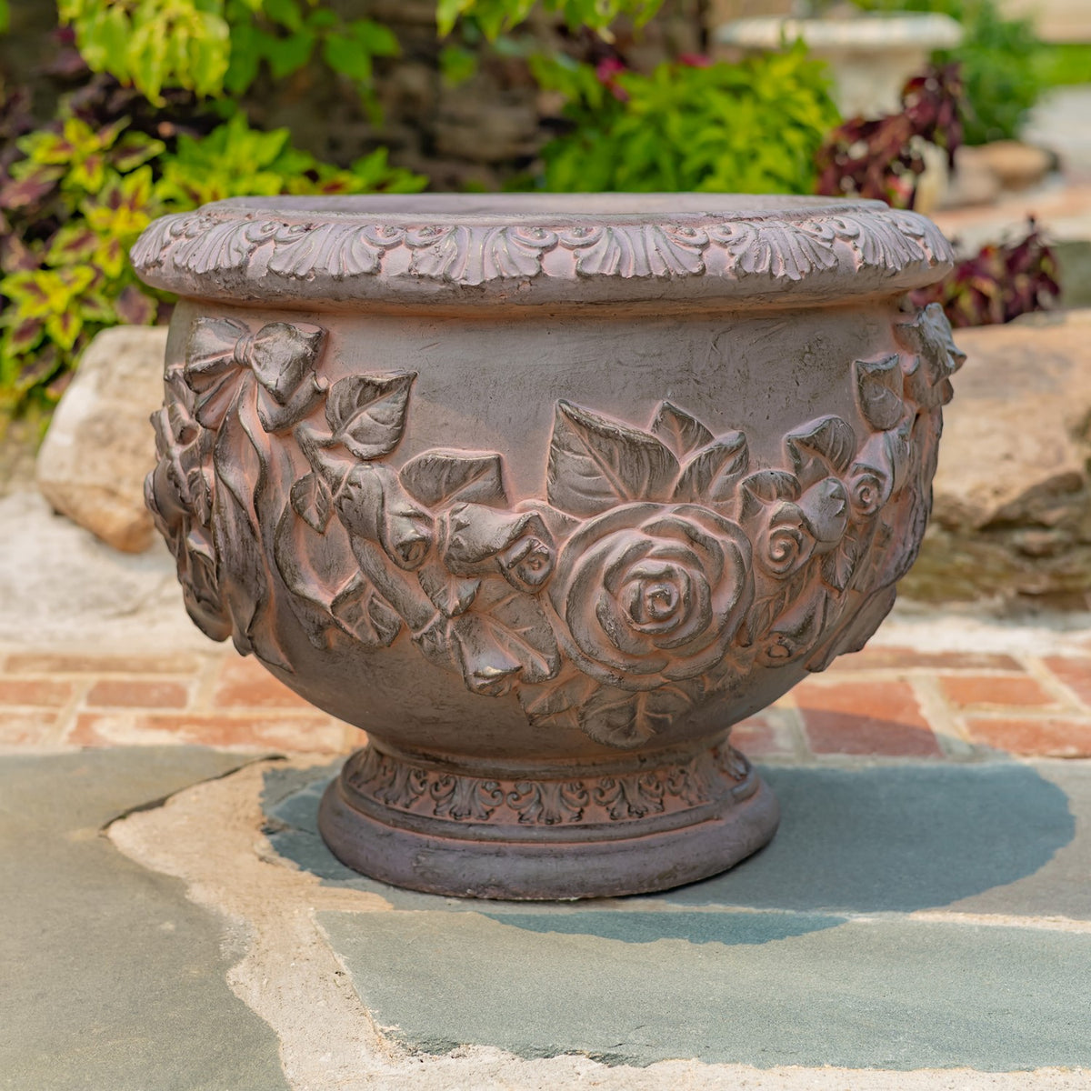 Close-up of raised roses and leaves decorating the planter's curved exterior.