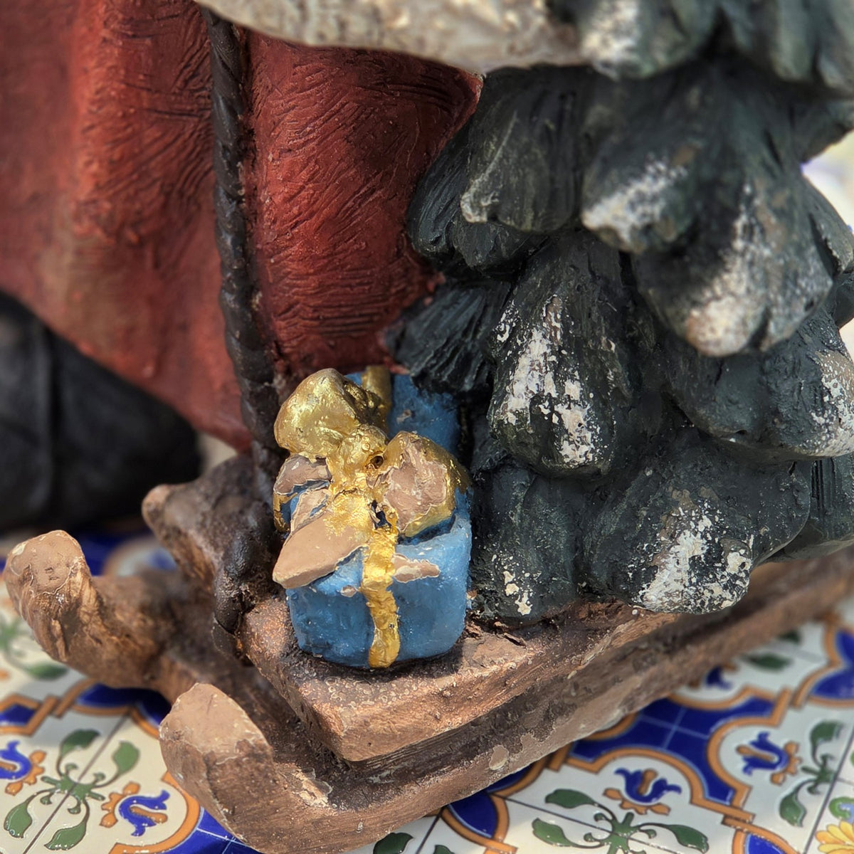 Detail of the small tree and wrapped gift at Santa's feet