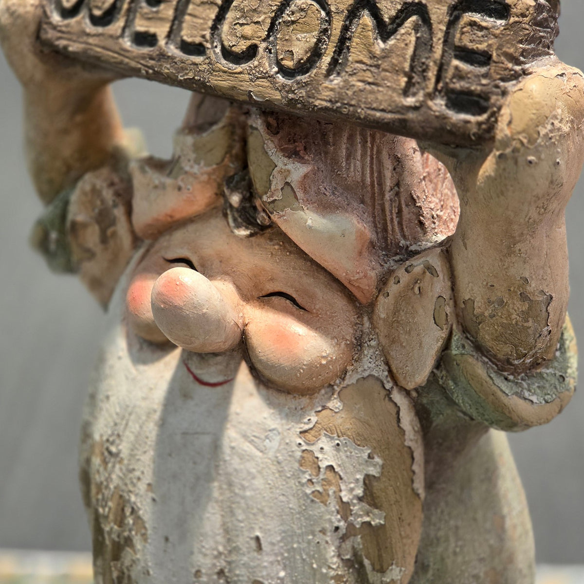 Close-up of the gnome's face and raised welcome sign with distressed finish