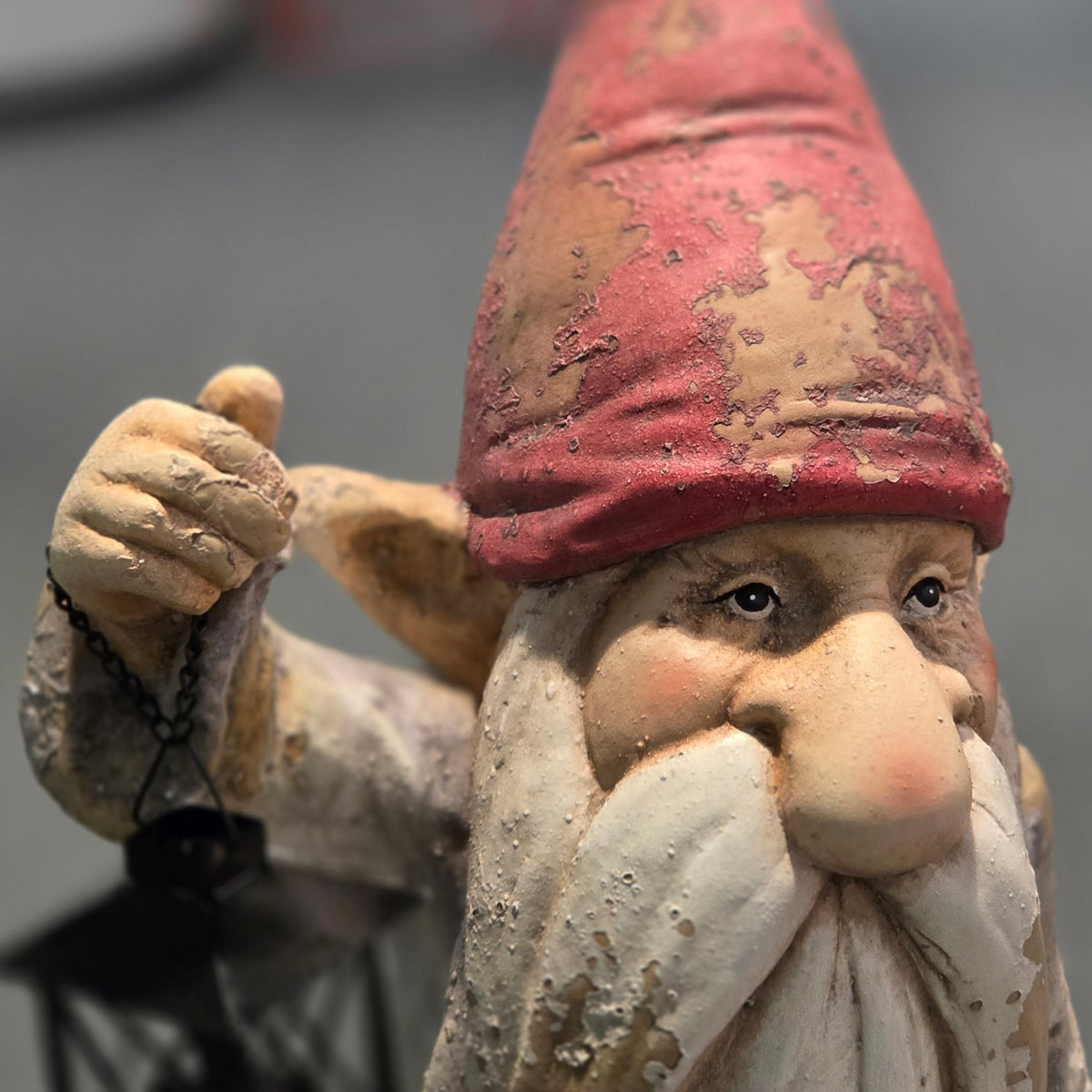 Close-up of the gnome's face, distressed red hat and hanging lantern