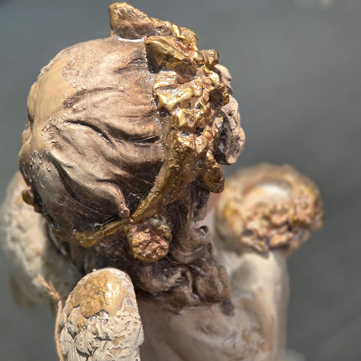 Close-up of the angel figurine's hair and gold flower crown from behind