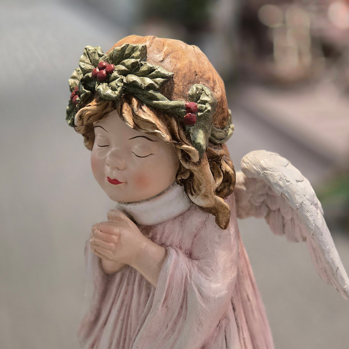 Side view of the praying angel in a blush gown with one white wing visible