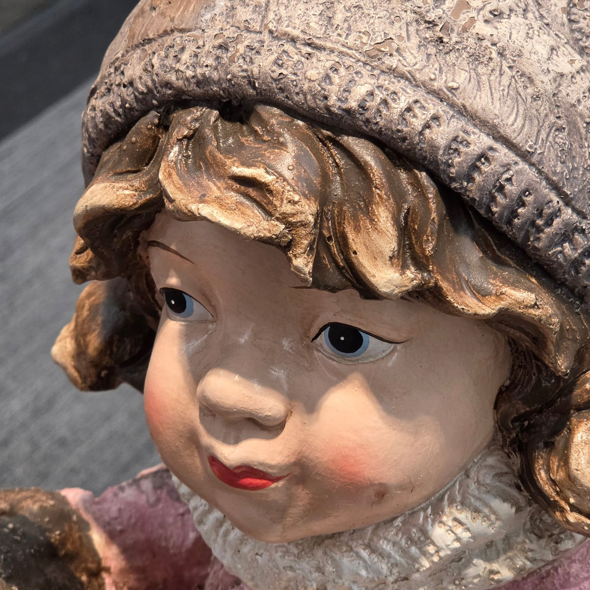 Extreme close-up of the girl's face beneath her textured hat