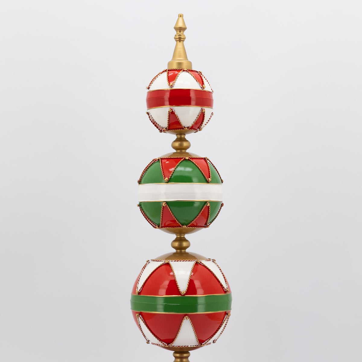 Upper portion of the ornament tower, showing three stacked red, green, and white patterned spheres.