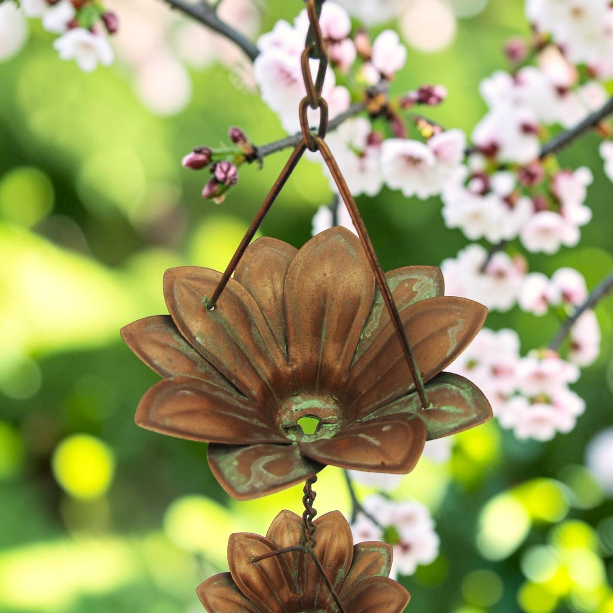 View beneath a flower-shaped rain chain cup, showing its central opening and chain connection.