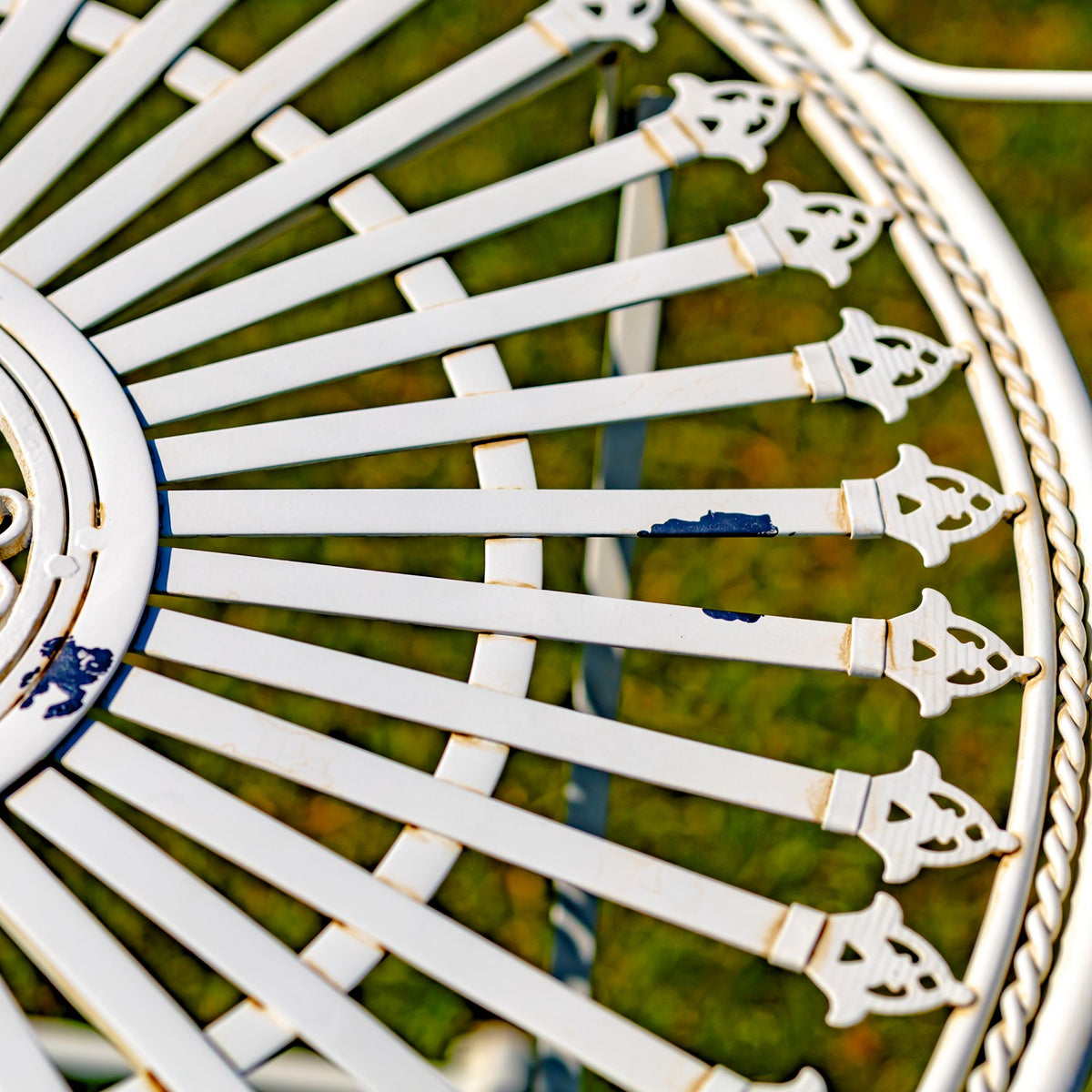 White metal spokes ending in small decorative shapes along the curved outer rim of the tabletop.