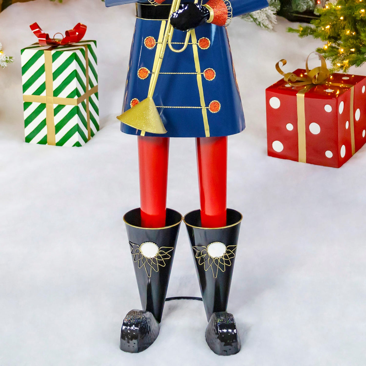 Close-up of the nutcracker's red trousers and black boots on a snowy display floor