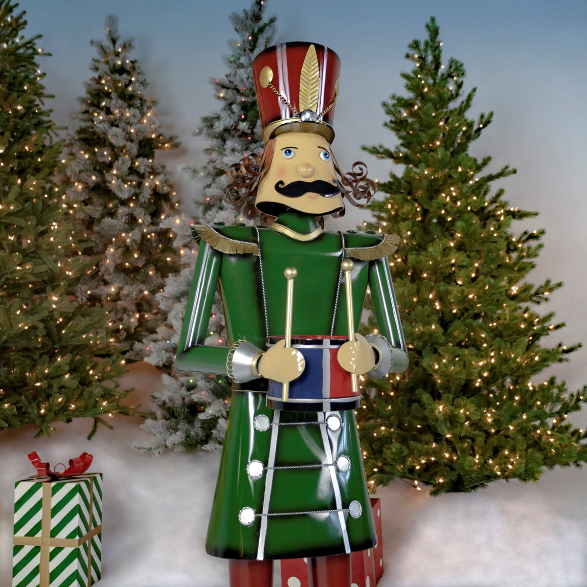 Green drum-holding nutcracker shown at an angle beside Christmas trees