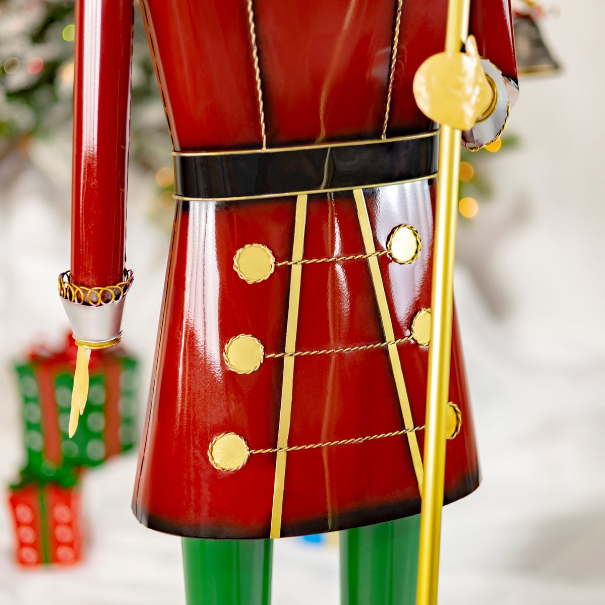Close-up of the burgundy nutcracker uniform with gold buttons, trim and baton