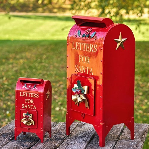 Two red holiday mailboxes with gold details shown at an angle on a sunny lawn
