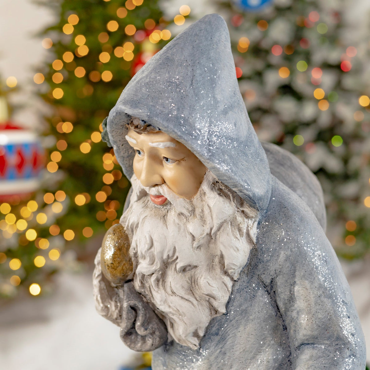 Angled close-up of Santa's hood, white beard and gold-colored toy bag