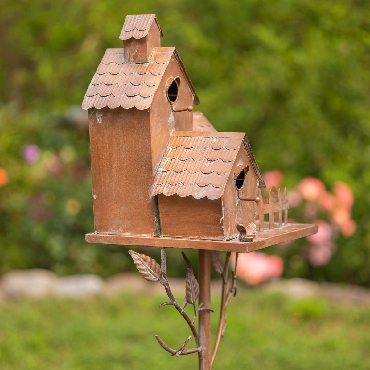 Side view of the birdhouse cluster showing layered shingled roofs and stake