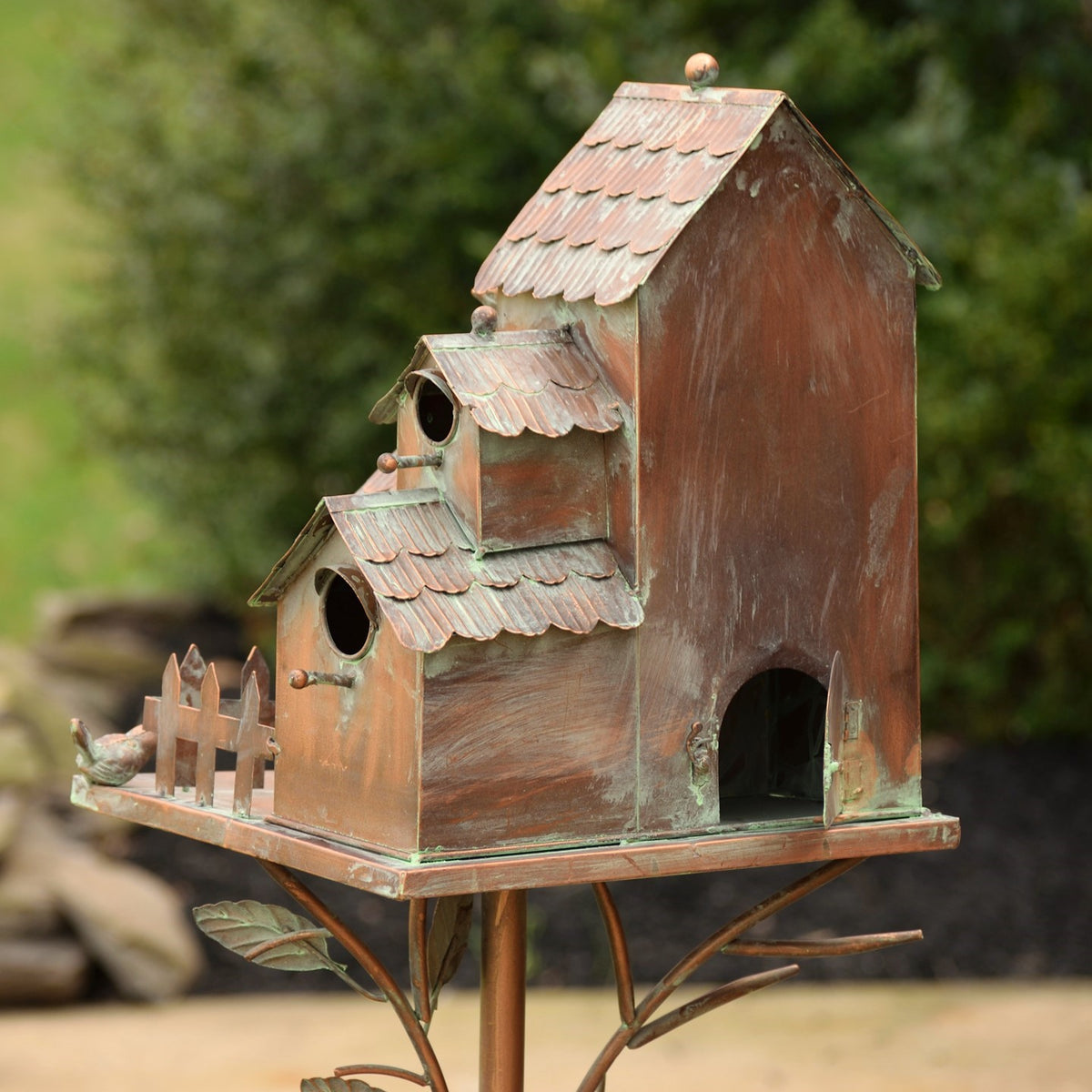 Rear angled view of the antique copper birdhouse stake showing the house backs