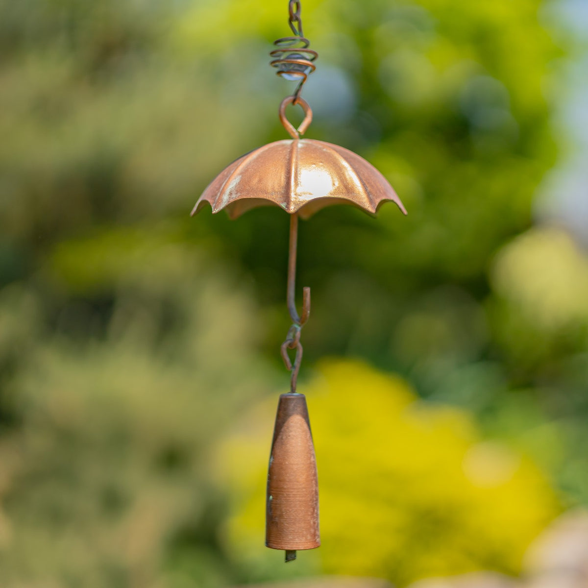 Close-up of a copper umbrella detail and bell on the wind chime