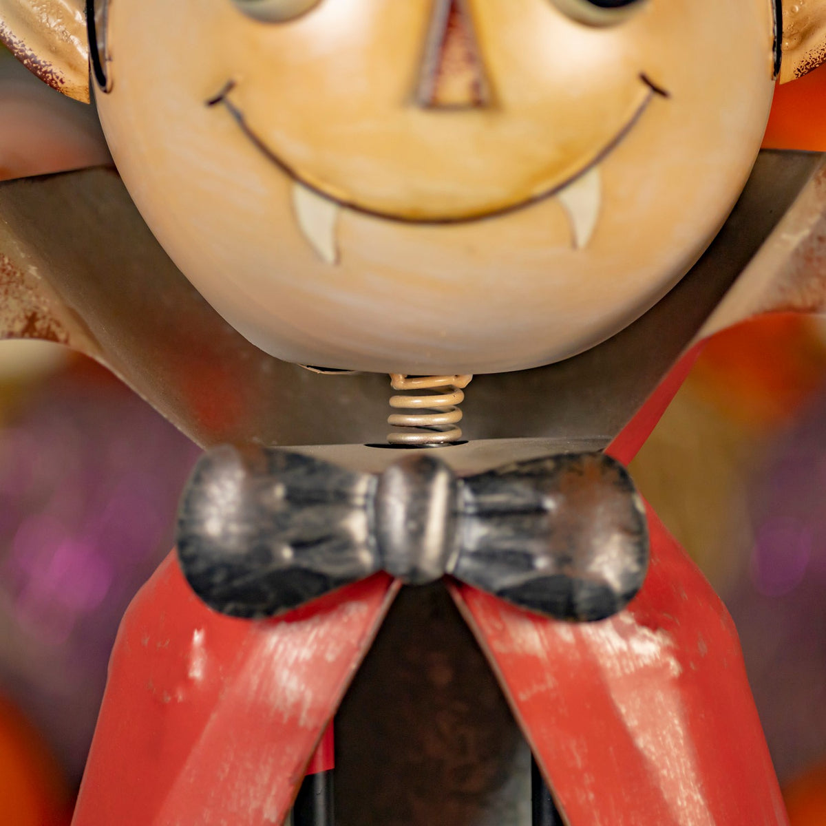 Close-up of the vampire figurine's fanged face, bow tie, and red cape