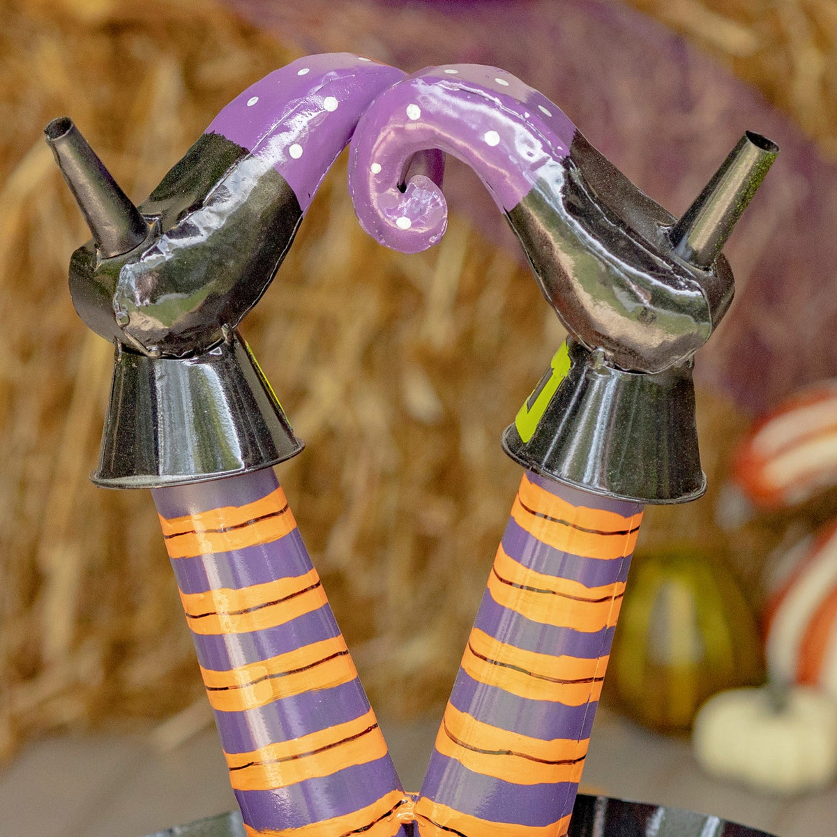 Detail of the witch's curled purple shoes and orange-striped legs