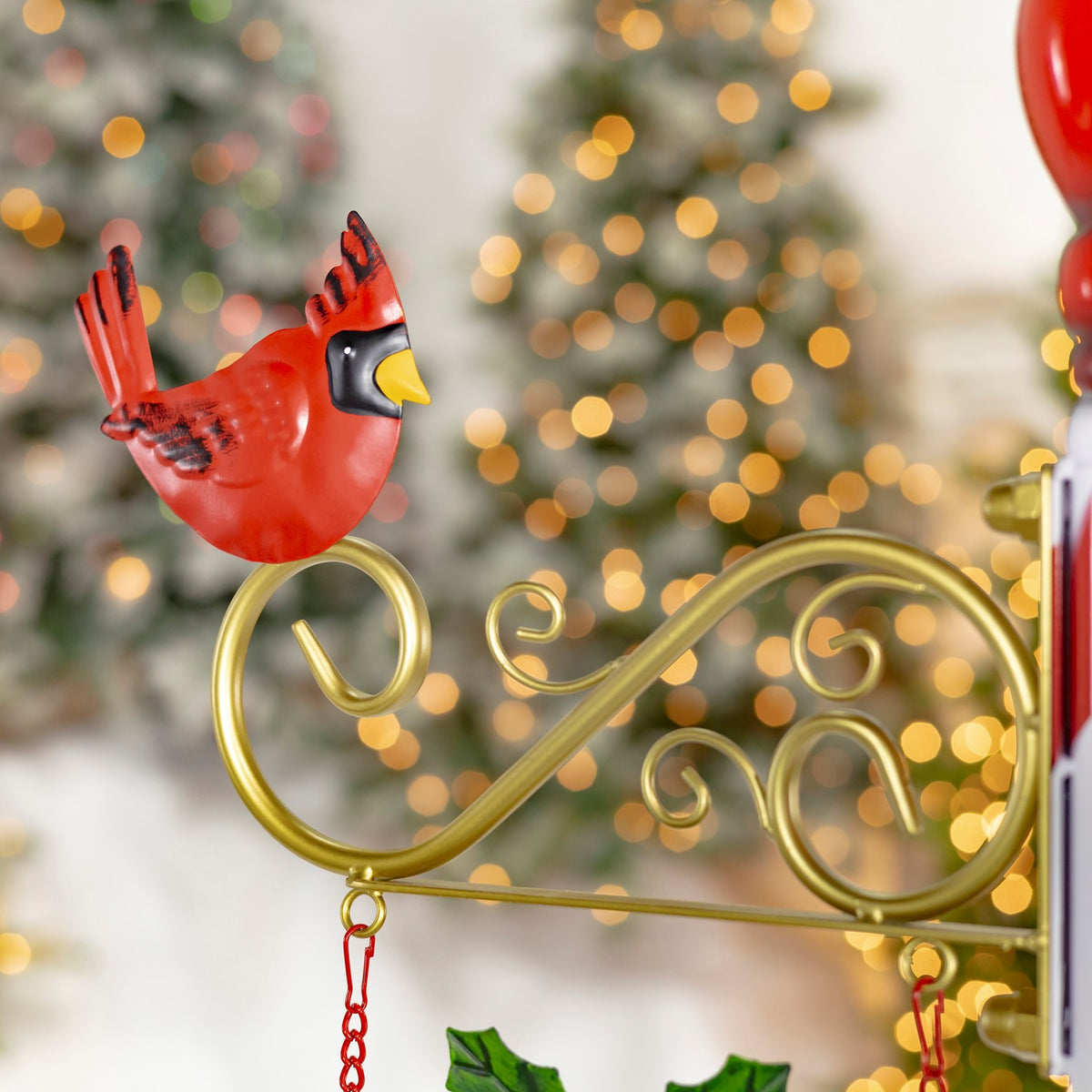 Red cardinal perched on gold scrollwork beside the striped post, with blurred holiday lights behind it.