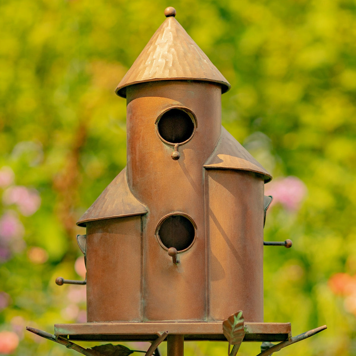 Close view of the antique copper birdhouse stake and its three homes