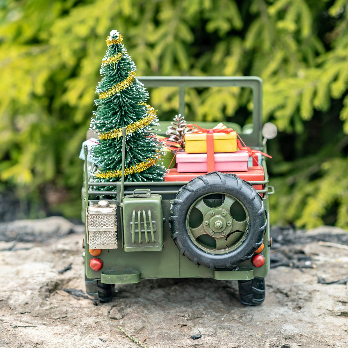 Army-green military vehicle with tree and gifts, straight rear view
