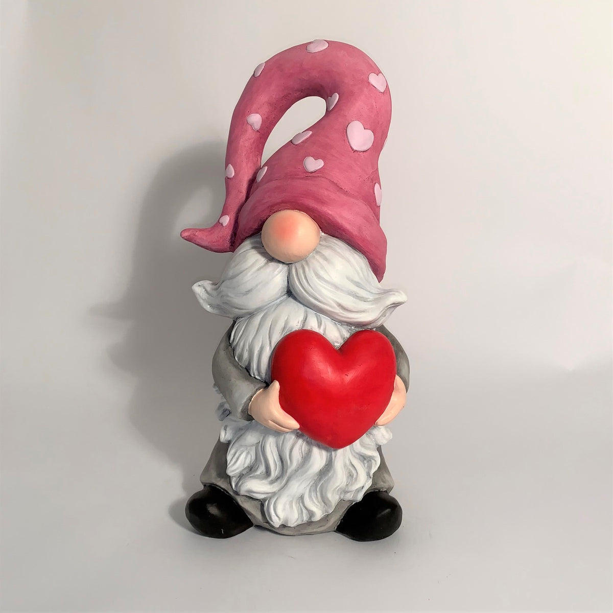 Front view of a heart-holding gnome against a plain light background