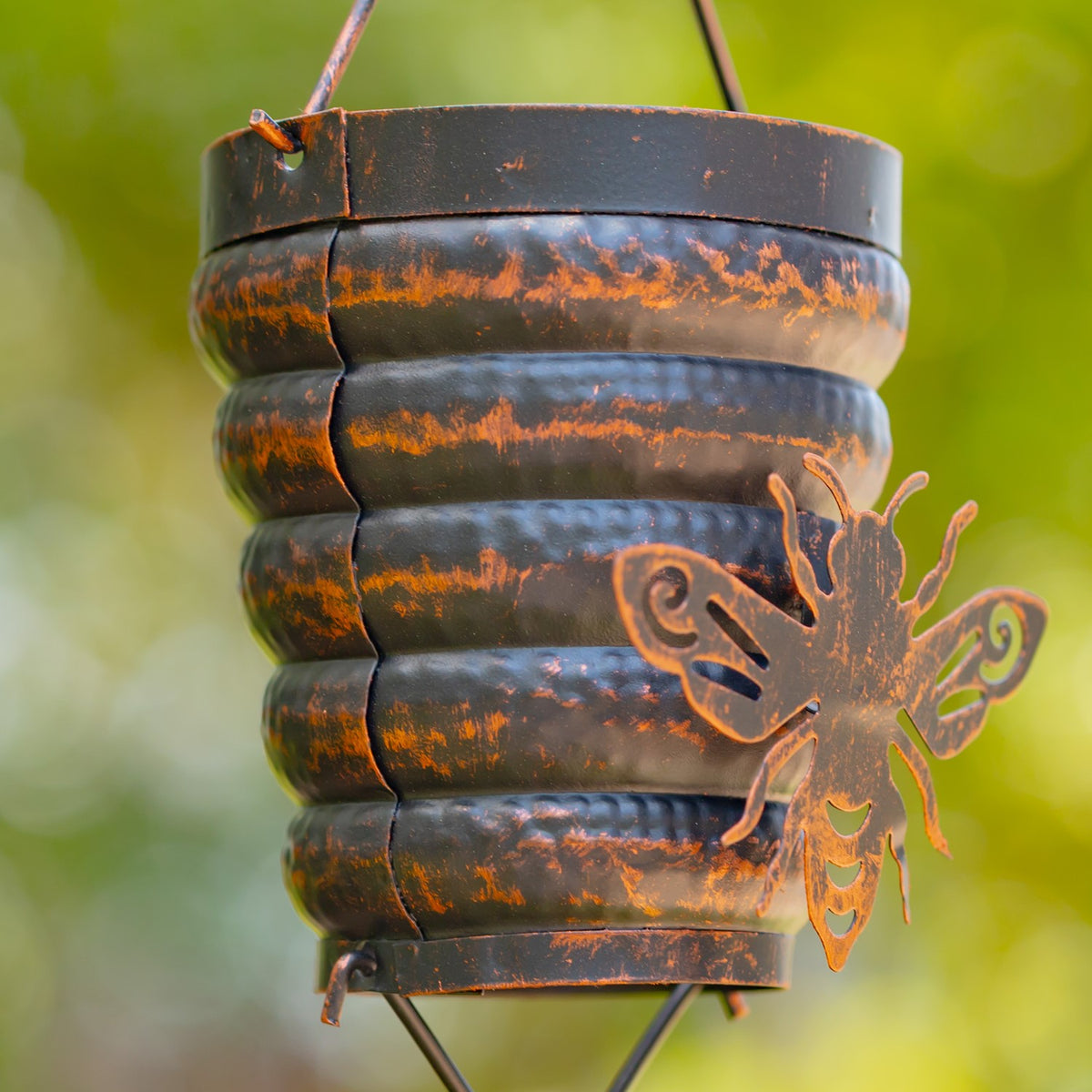 Close-up of the distressed bronze finish and bumble bee detail on a hive cup