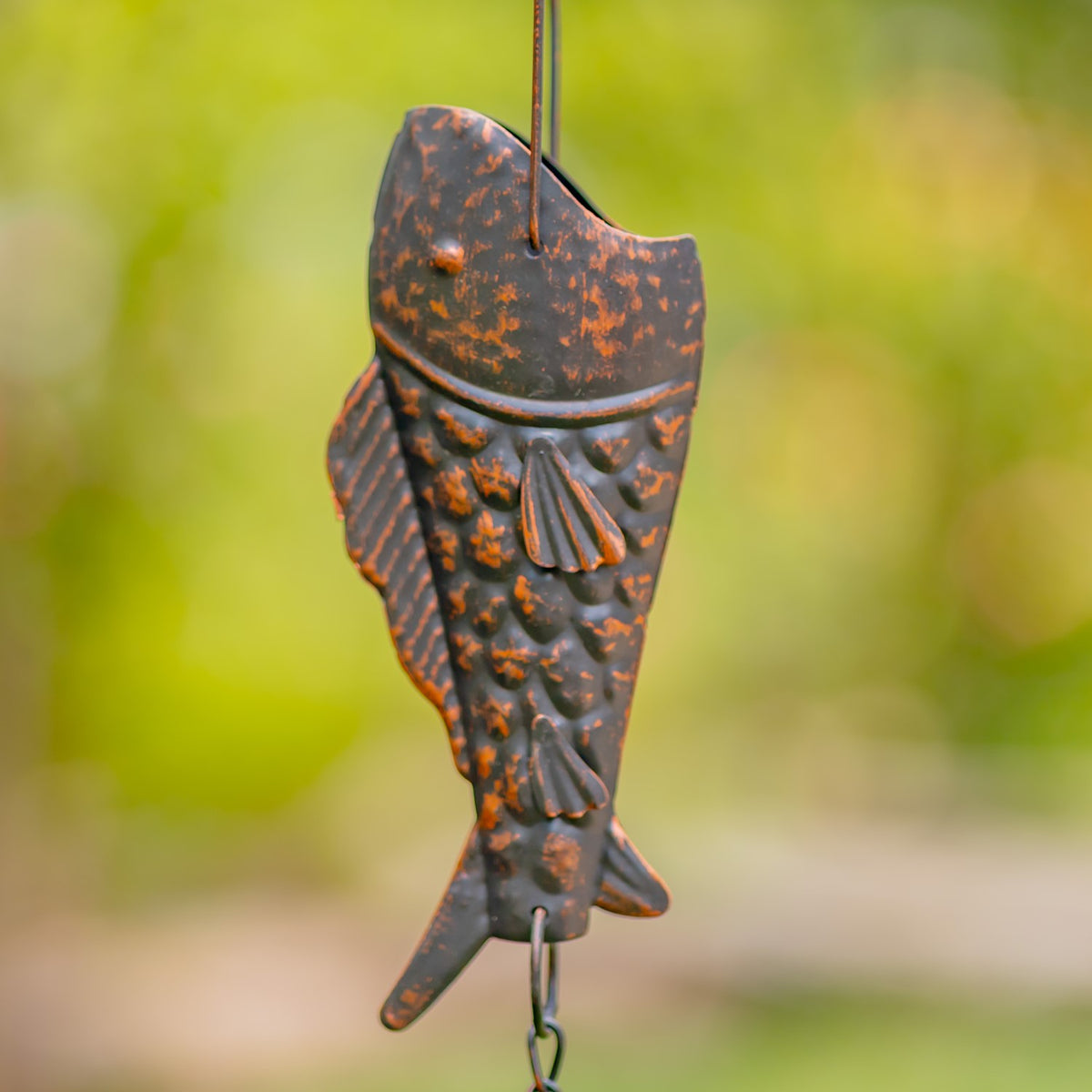 Close-up of a textured antique bronze trout on a hanging chain