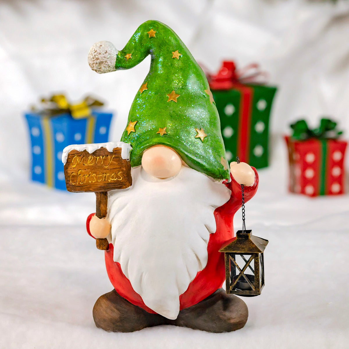 Red-clad gnome in a green hat holding a Christmas sign and lantern