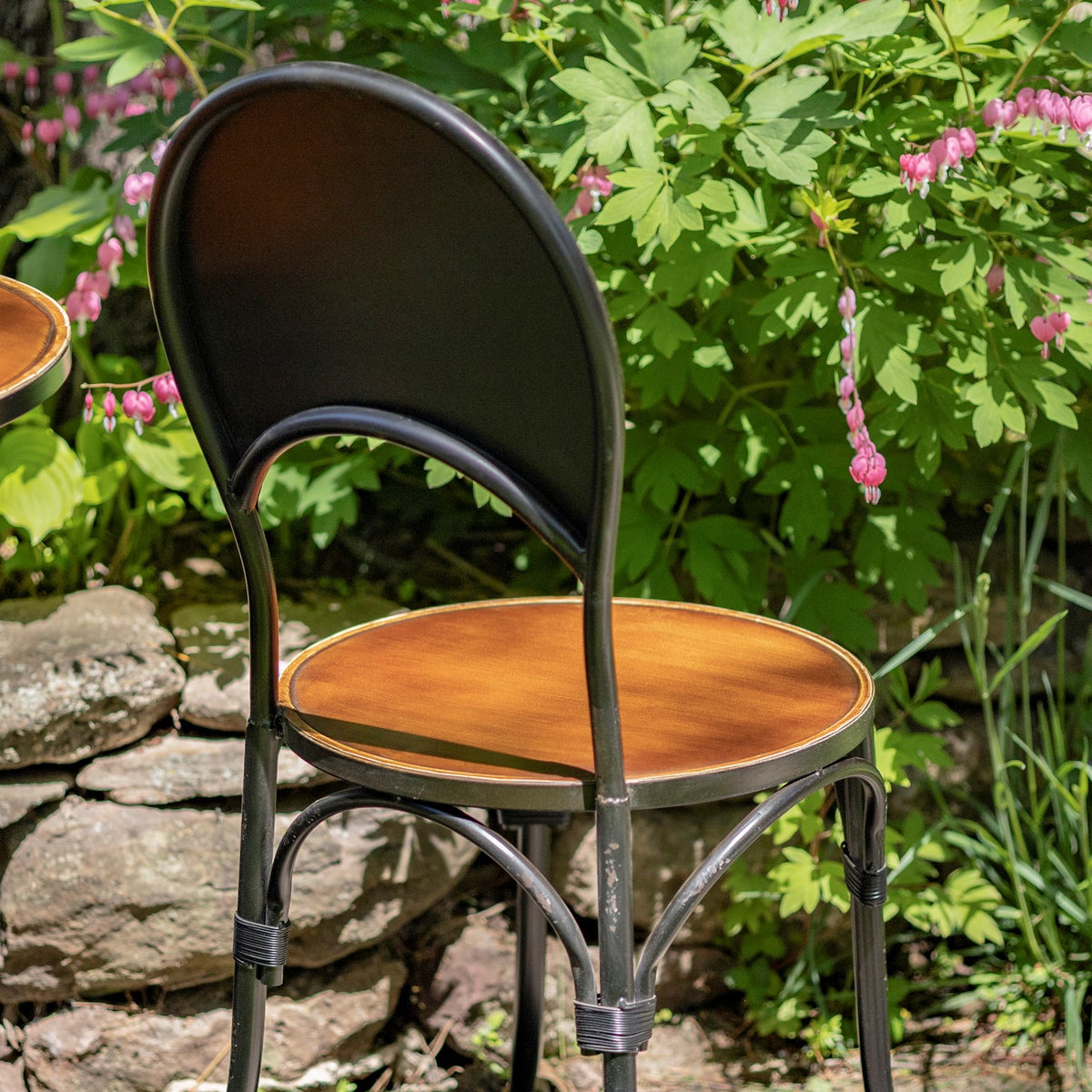 Close view of a copper-finish chair with a curved back and iron frame