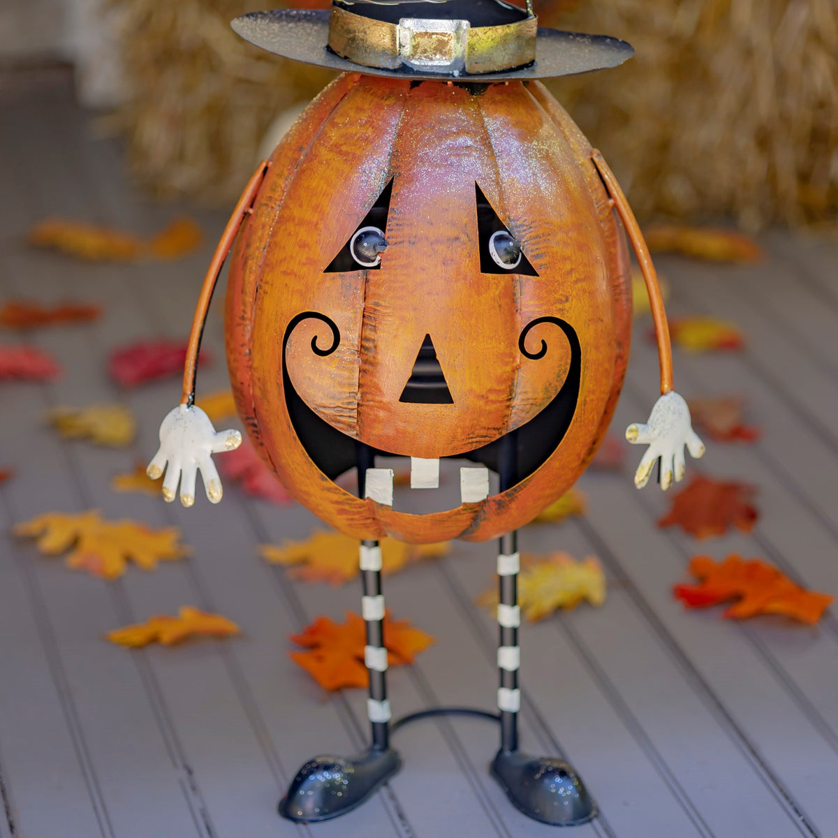 Front view of the jack-o'-lantern figurine with striped legs and witch hat