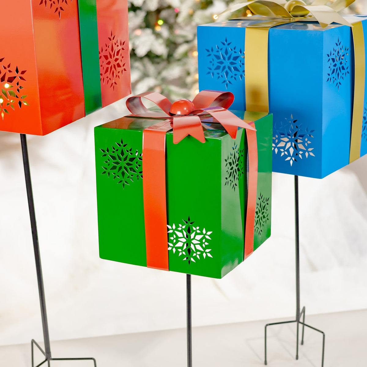Green gift-box stake with red bow between partial red and blue boxes