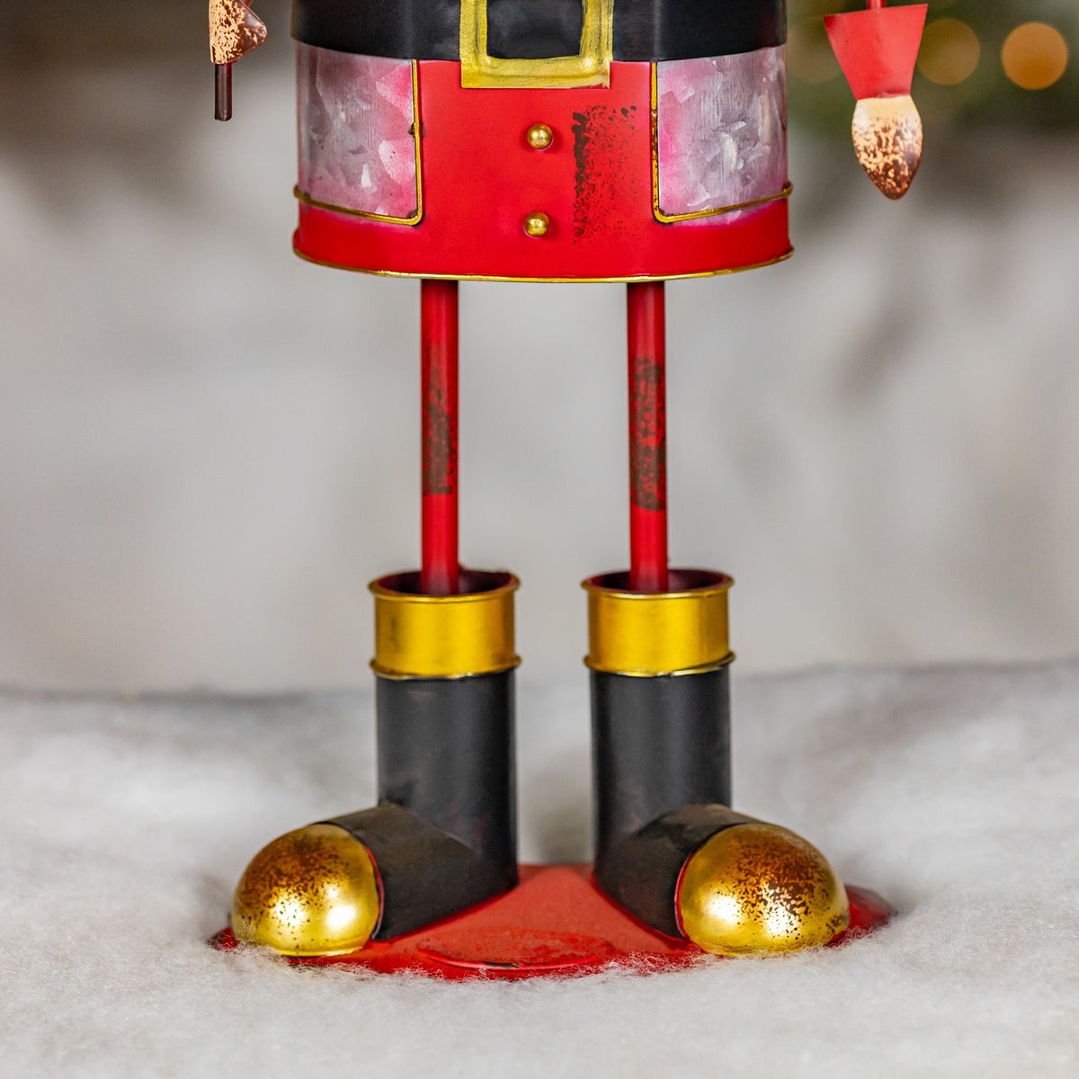 Close-up of the nutcracker's red legs and black boots with gold details
