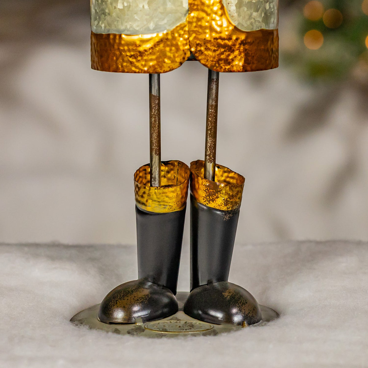 Close view of Santa figurine's dark boots and gold-trimmed legs