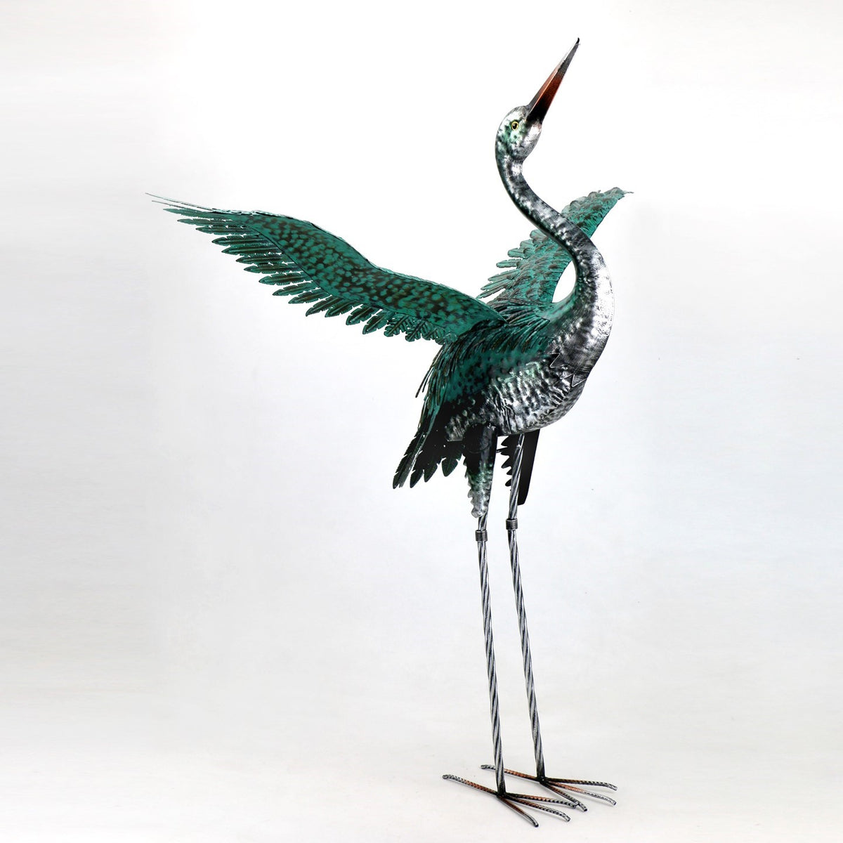 Metal heron figurine with one wing spread, a curved neck, and long legs.