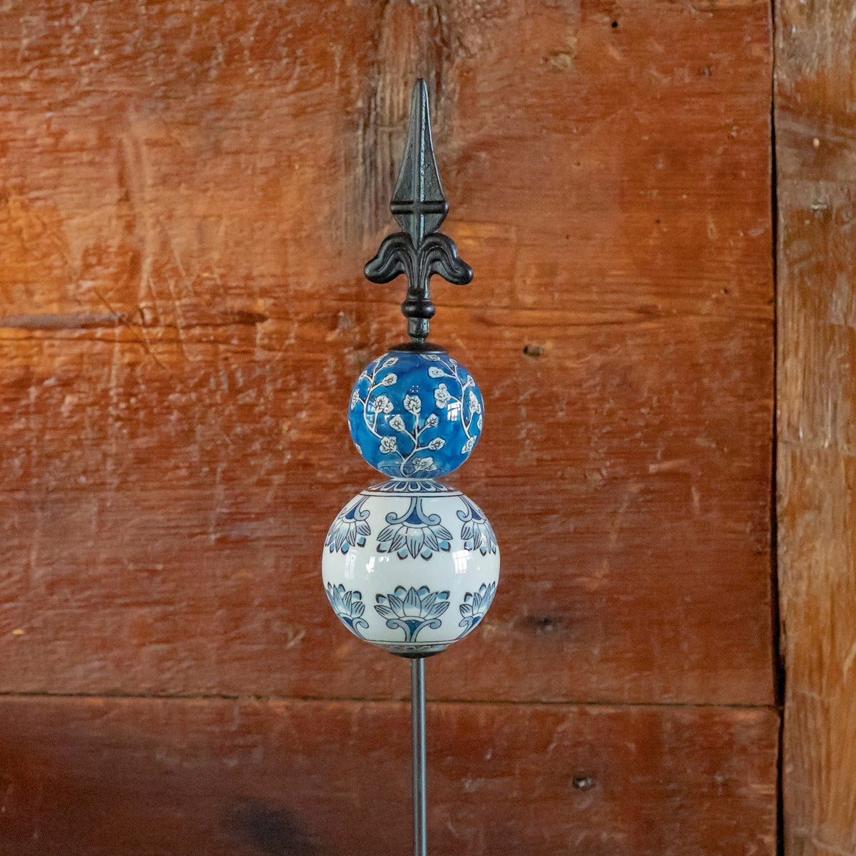 Blue and white patterned ceramic spheres topped with a black iron finial