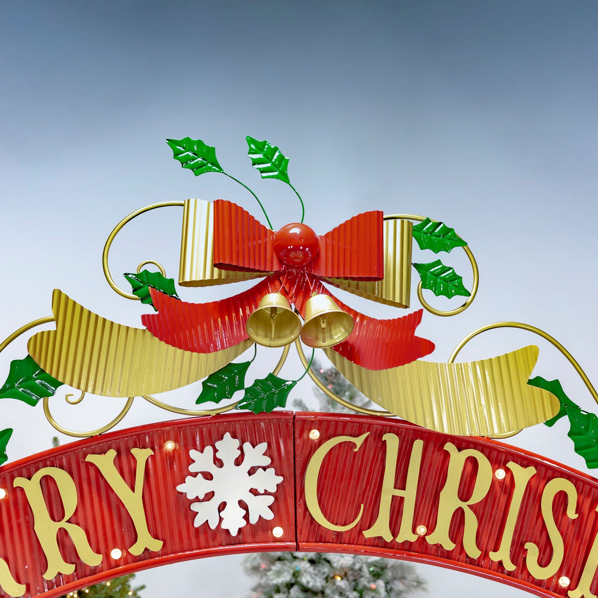 Close-up of the arch's red Christmas banner, gold lettering, bow and holly