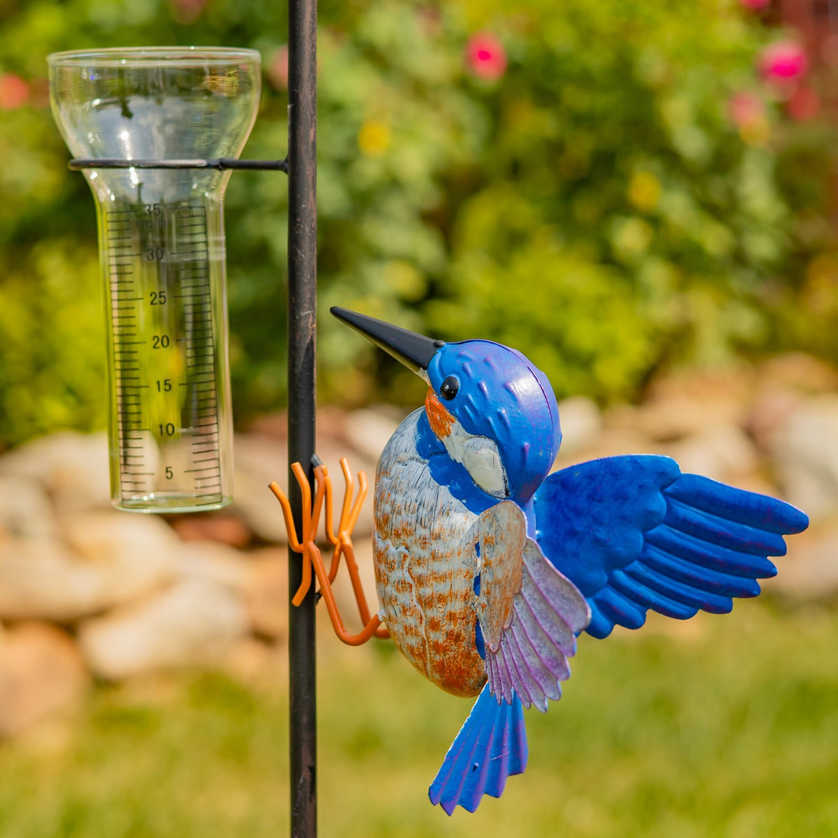 Painted hummingbird and glass rain gauge shown together in close view