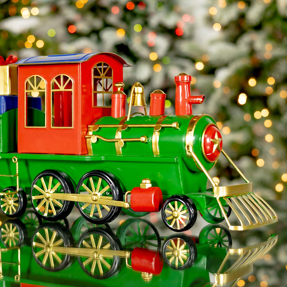 Front three-quarter view of a green Christmas train with a red cab