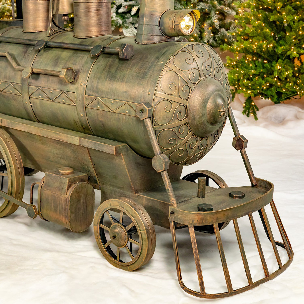 Close-up of the antique bronze locomotive front and cowcatcher in snow