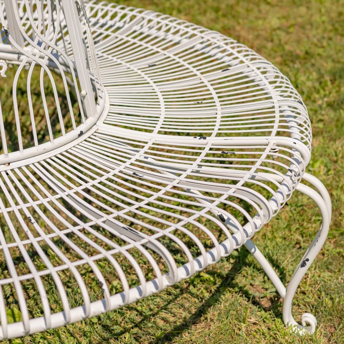 Close view of the rounded wire seat where it curves around the central backrest.