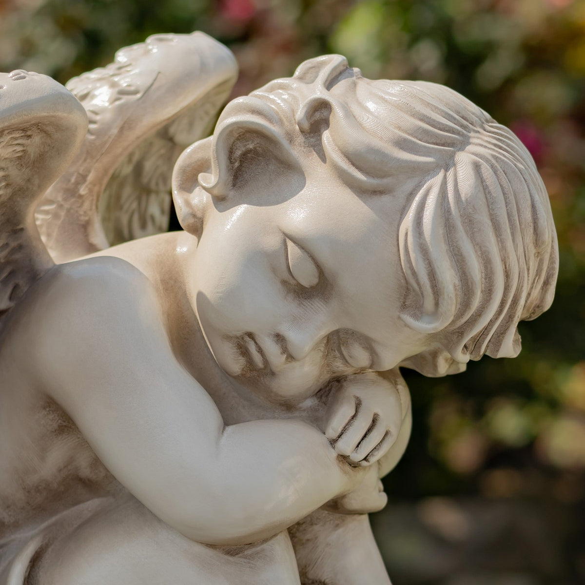 Detailed close-up of a cherub statue's face, hair, and folded arms