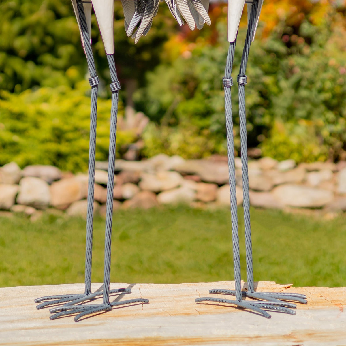 Close-up of the figurines' slender legs and freestanding metal bases
