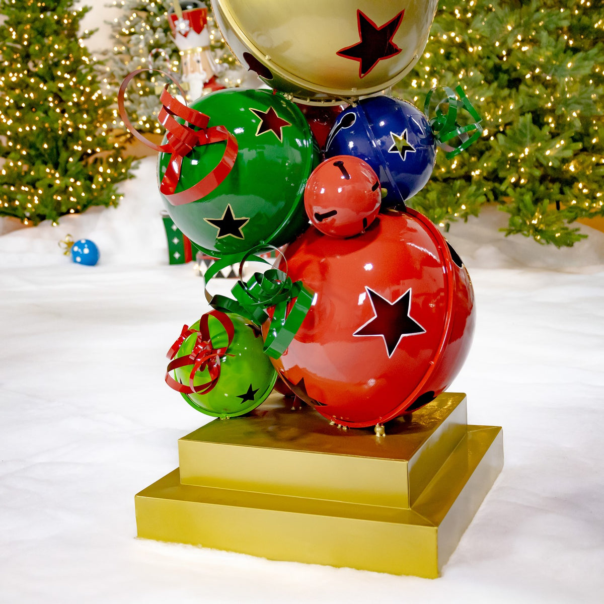 Close-up of colorful star-cutout bells above a square gold base