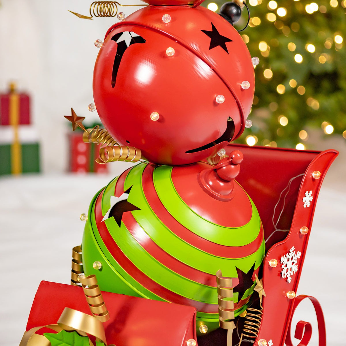 Close view of a red-and-green jingle-bell figure seated in a decorated red sleigh.