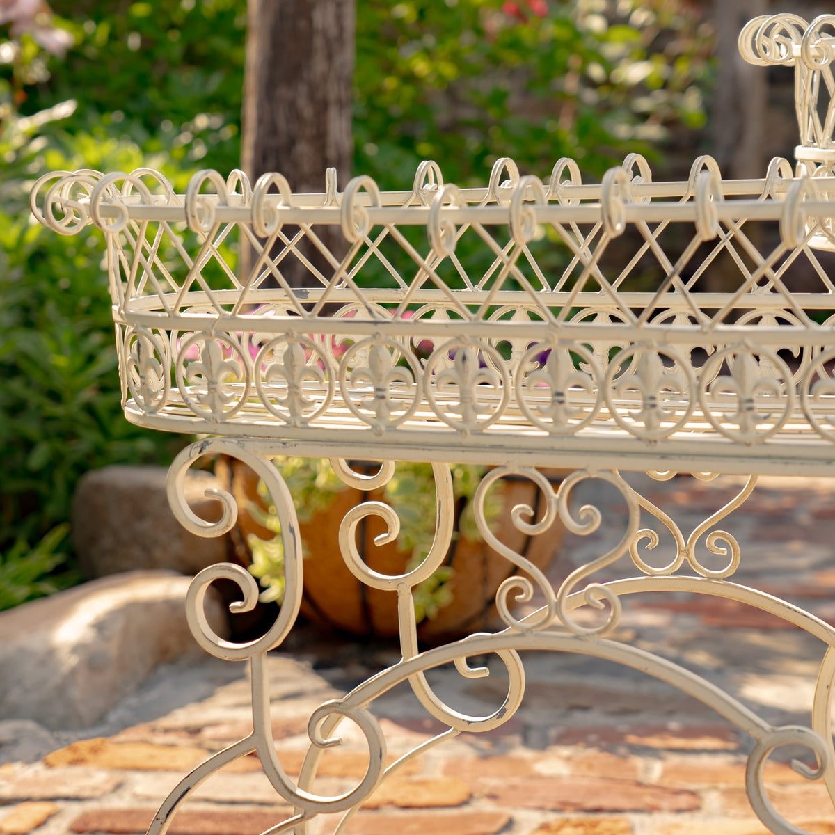 Side view of an embellished oval basket and the stand’s curled metal supports.