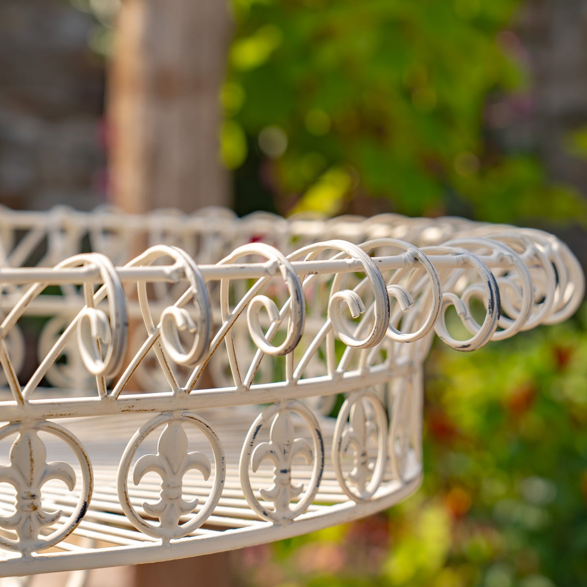 Close view of the basket rim, showing curled wire loops and circular ornamental cutouts.