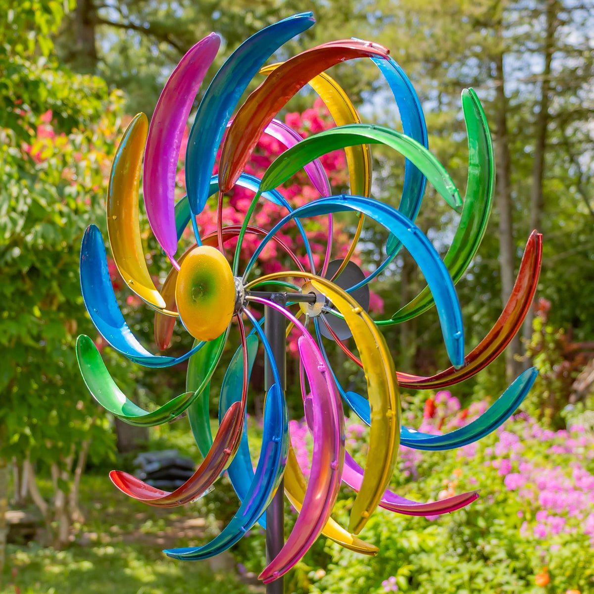 Angled close view of colorful painted windmill blades in a garden