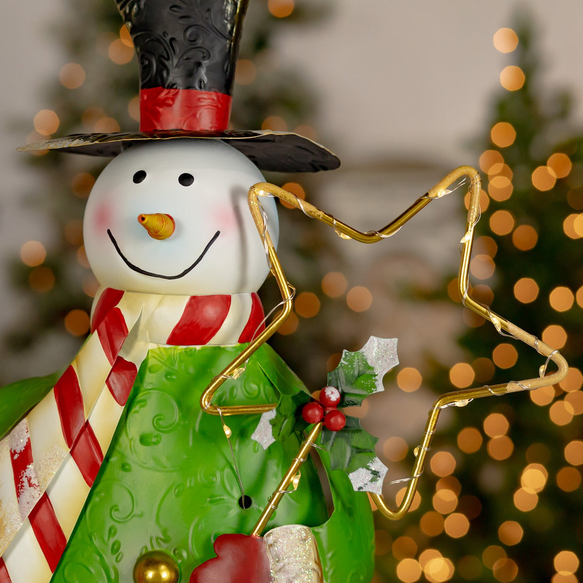 Close-up of a smiling snowman in a black top hat and green coat holding a glowing star outline.